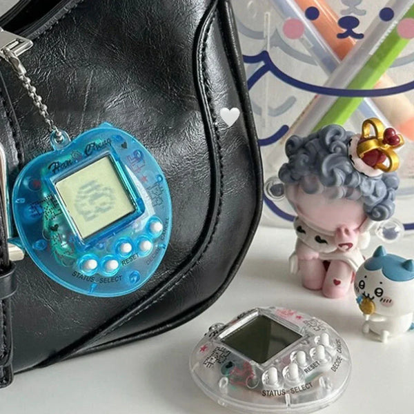Llaveros digitales estilo Tamagotchi en colores azul y transparente junto a figuras kawaii, accesorios originales y divertidos