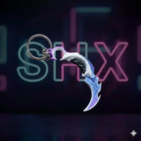 Llavero gamer con forma de cuchillo karambit metálico decorado, fondo neon.