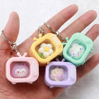 Llaveros kawaii en forma de televisor, colores pastel y diseños de flor, pata y osito.