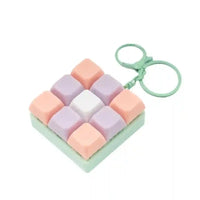 Llaveros SHX con teclado clickeable en tonos pastel rosa, lila y blanco con aro verde
