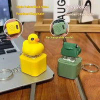 Yellow duck and green frog voice pendant keychain with rechargeable models placed on wooden table and laptop